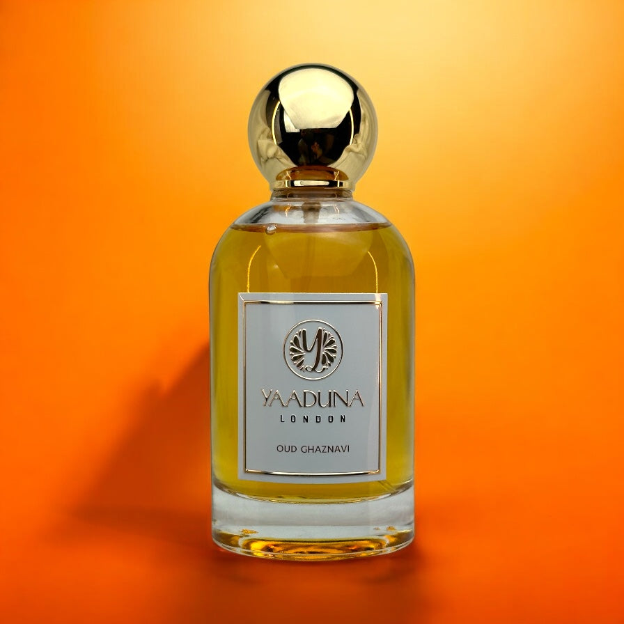 OUD GHAZNAVI perfume bottle by YAADUNA London with golden cap on orange background